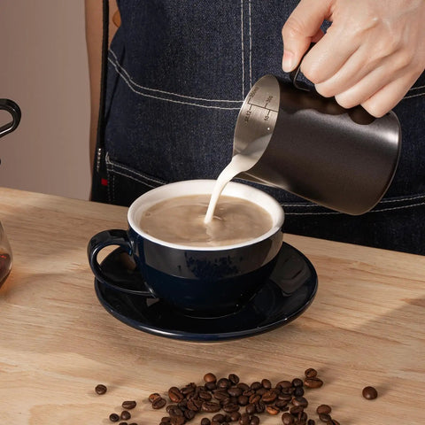 Pouring milk from 12Oz Stainless Steel Milk Frothing Pitcher With V Shaped Spout And Teflon Coating into coffee cup