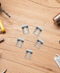 Universal Auto Windshield Wiper Linkage Repair Clips Kit Built Tough With Heavy Duty Stainless Steel displayed on a workbench.