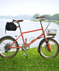Orange bike with basket and bag by a lake, suitable for use with Go To 20 Inch Bike Inner Tube 1.75 To 2.125 For Mountain Road City Cruisers