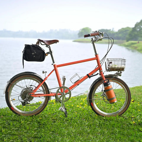 Orange bike with basket and bag by a lake, suitable for use with Go To 20 Inch Bike Inner Tube 1.75 To 2.125 For Mountain Road City Cruisers