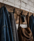 Built Tough 4 Pack Western Bull Horn Hat Hooks In Matte Black Cast Iron Wall Rack with jackets and a purse hanging.