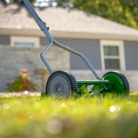 Side view of No Sweat 14 Inch 5 Blade Push Reel Lawn Mower with ball bearing reel and cushioned T-style handle on grass.