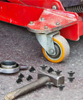 105 Pcs Black Rubber Jack Oil Plug Set For Floor Bottle Jacks next to a red jack wheel on workshop floor
