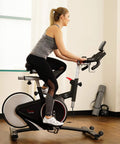 Smooth Riding Indoor Cycling Bike Featuring Forty Pound Rear Flywheel And Digital Console To Dominate Your Daily Grind And Ride With Silent Magnetic Resistance Upgrading Your Whole Home Gym Setup in use by a rider.