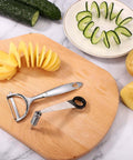 Stainless steel vegetable spiralizer and peeler set on wooden board with spiral potato slices and cucumber ribbons