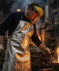 Badass Aluminized Heat Resistant Cover With Rock Solid Fireproof Safety Gear For Foundry Furnace Welding And Glass Blowing Hella Tough Heavy Duty Barbecue Bib shielding molten metal while pouring.