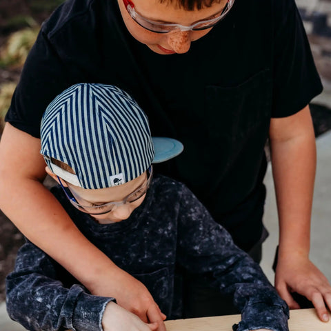 Kids wearing blue safety glasses engaged in outdoor play and STEM activities, showcasing Kids Blue Safety Glasses Lightweight Protective Eyewear For School And Lab Use Comfortable All Day Fit Scratch Resistant For STEM Projects Outdoor Play And Chemistry Experiments.