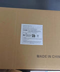 Cardboard shipping box with label and 'Made in China' text, placed on a dark surface.