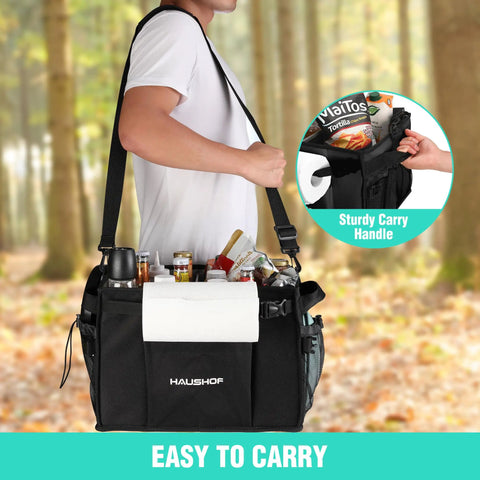 Person carrying Large Grill And Picnic Caddy with paper towel holder, condiment pockets, in forest setting, easy carry design