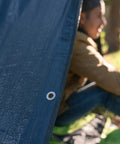 Side view of Medium Duty Ripstop Camping Tarp 6 By 8 Feet Waterproof Cover Dark Green 5 Mil Thick With Reinforced Grommets providing shelter.