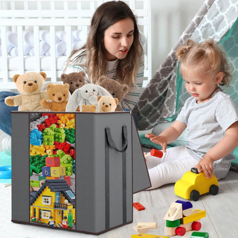 Gray storage bag filled with toys next to child playing, featuring Massive 120L Blanket Storage Bags With Reinforced Handles Breathable 100 GSM Fabric.