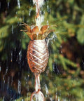 Copper Pineapple Rain Chain Eight And A Half Foot Long Handcrafted 20 Gauge Pure Copper With Brass Accents Patina Finish outdoors.
