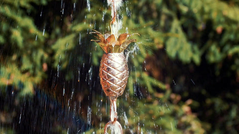 Copper Pineapple Rain Chain Eight And A Half Foot Long Handcrafted 20 Gauge Pure Copper With Brass Accents Patina Finish outdoors.