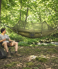 Man relaxing next to Two In One Pop Up Hammock Tent With Mosquito Net For One Person, Instant Outdoor Setup With Breathable Mesh.