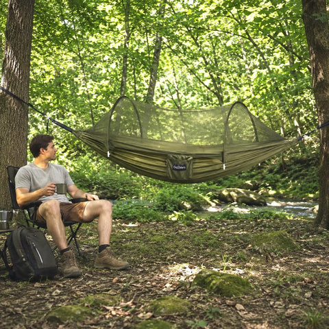 Man relaxing next to Two In One Pop Up Hammock Tent With Mosquito Net For One Person, Instant Outdoor Setup With Breathable Mesh.
