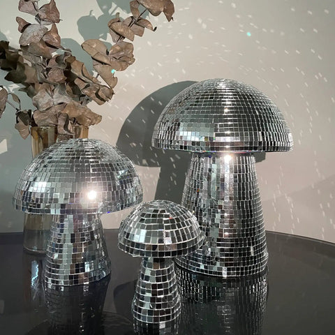 Three silver mushroom disco balls with mirrored squares reflecting light, suitable for party decor and stage props.