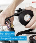 Hands wrapping wires with High Performance PET Cloth Automotive Wire Harness Tape Black 19mm x 25m 5 Rolls for protection.