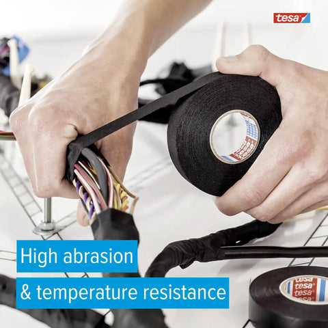 Hands wrapping automotive wires with Heavy Duty PET Cloth Automotive Wire Harness Tape Black 19mm X 25m Roll for cable protection.