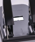 Close-up of Workhorse Two Hole Puncher For Paper With 30 Sheet Capacity Adjustable Guide And Locking Mechanism, black office tool.