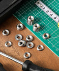 Front view of #8 countersunk finishing washers, 304 stainless steel, cup style, silver, on cutting mat with ruler