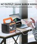 Portable Power Station 230Wh With 300W Continuous Power And 600W Peak next to laptop and phone charging on desk