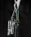 Beefed Up Heavy Duty Titanium Zipper Pull Replacement Kit attached to black fabric showing multiple metallic tools and accessories