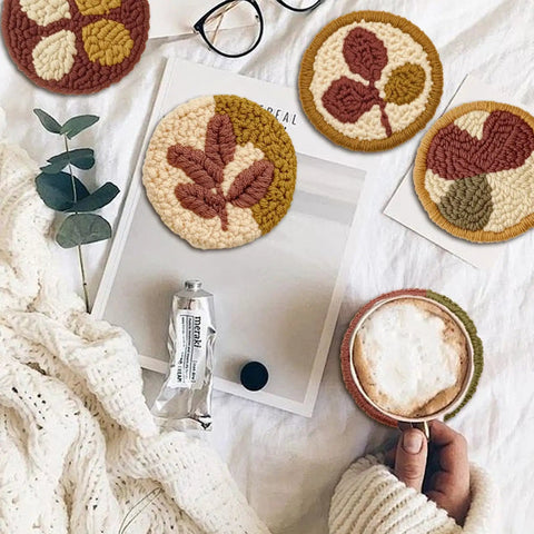 Six Piece Punch Needle Coaster Kit Set For Beginners And Adults, DIY Embroidery Craft with patterns and yarns on cozy table
