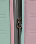 Close-up of mint carry-on hardside luggage with pink and teal panels and a visible zipper pull