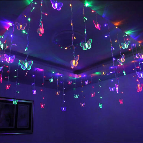Butterfly Curtain String Lights With Remote USB Powered 48 LED Twinkle Lights 8 Modes Perfect For Bedroom Window Decor Party Wedding Holiday Christmas Multi Colored Glow Four Point Nine Feet installed on ceiling casting multicolor glow