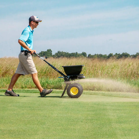 Person using Spyker All Season Spreader Kit Ergo Pro 50 Pound Broadcast Spreader With 25 Pound Bag Spreader on lawn
