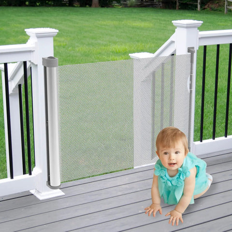 Retractable Baby And Pet Safety Gate 54 Inch Wide 34 Inch Tall for doorways hallways and stairs, gray one-hand operation shown outdoors
