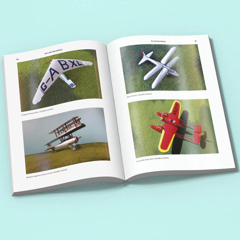 Open book showing "Conversions and Scratchbuilding Masterclass for Aircraft Modeling with Hands On Pro Tips and Superdetailing Weathering for Builders to Elevate Your Plastic Aircraft Projects" with model planes images.