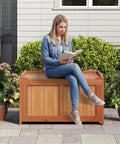 Woman sitting on Wood Deck Storage Box 52 Gallon For Patio Cushions And Pillows Garden Tools Pool Accessories And Outdoor Gear