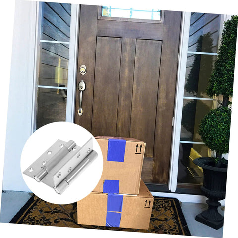 Residential door spring hinge set for double-opening doors, stainless steel hardware on a wooden front door.