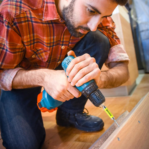 Person using 2-Pack Quick Release Magnetic Drill Bit Holder With One-Hand Swap on a wooden surface, close-up of drill and bit
