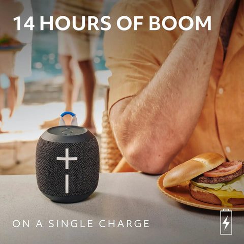 Wonderboom 4 Portable Bluetooth Speaker With Waterproof Floating Design on table near sandwich, 14h playtime display