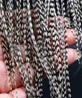 Close-up of 10-Piece Black And White Dry Fly Tying Feather Set With Presized Saddle Hackles 6-9 Inches Long Sizes 12 Through 14