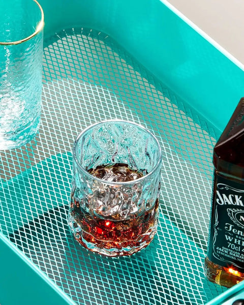Close-up of Three Tier Mesh Rolling Cart On Wheels With Handle Turquoise Finish showing mesh surface with beverage items.