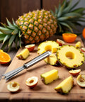 V Shape Pineapple Eye Remover Tool with multipurpose clip peeler on cutting board with sliced pineapple and fruits