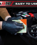 Person applying adhesive for Heavy Duty Silicone Car Battery And Engine Block Heater Pad With Quick Ice Melter Shield in vehicle.