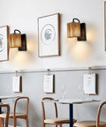 Boho Rattan Wall Sconce With Hemp Rope in rustic modern cafe setting with framed art on walls, cozy warm vibe ambience