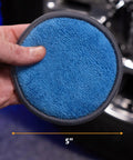 Hand holding blue microfiber pad, size 5 inch, for smooth wax application, part of Four Pack Five Inch Blue And Gray Microfiber Polishing Pads