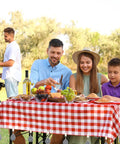Picnic with teardrop marble tablecloth weights with metal clips securing a red checkered tablecloth, 24 pack, outdoor dining