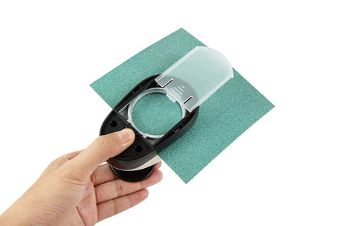 Hand holding a 2 Inch Circle Hole Punch Cutter for Paper Circles Craft Punch 50.8Mm Round Cutter for scrapbooking, cutting green paper