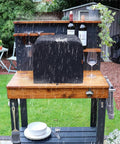 Waterproof Outdoor Pizza Oven Cover For Ninja OO101 Woodfire 8 In 1 Oven on a wooden table under rain