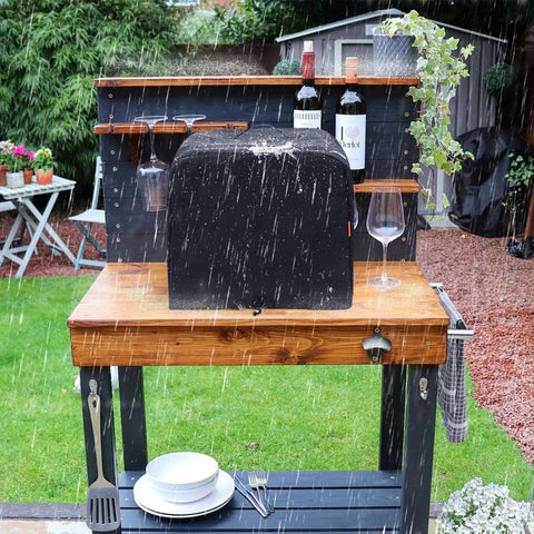 Waterproof Outdoor Pizza Oven Cover For Ninja OO101 Woodfire 8 In 1 Oven on a wooden table under rain