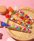 40 Pack Plastic Test Tubes With Rack And Color Coded Caps 12Ml 16X100Mm Polystyrene Clear Durable Lab Tubes For Science Class And Home Experiments Nerd Friendly Lab Kit filled with colorful candies on a wooden plate