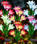 Lit Seven Color Changing Solar Lily Garden Lights With 24 LED Petals, outdoor flower lamps in a garden setting, 6 pack