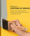 Hand using brush to paint edge of wall with gray paint, demonstrating service quality.