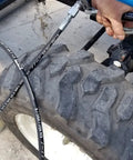 Pneumatic Grease Pump For 25-50Lb Pails, 40:1 Ratio Up To 4,000 PSI connected to tractor tire during lubrication.